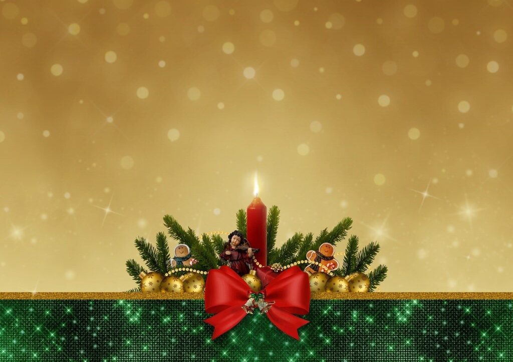 Obraz przedstawia bożonarodzeniowy stroik z zapaloną świecą.